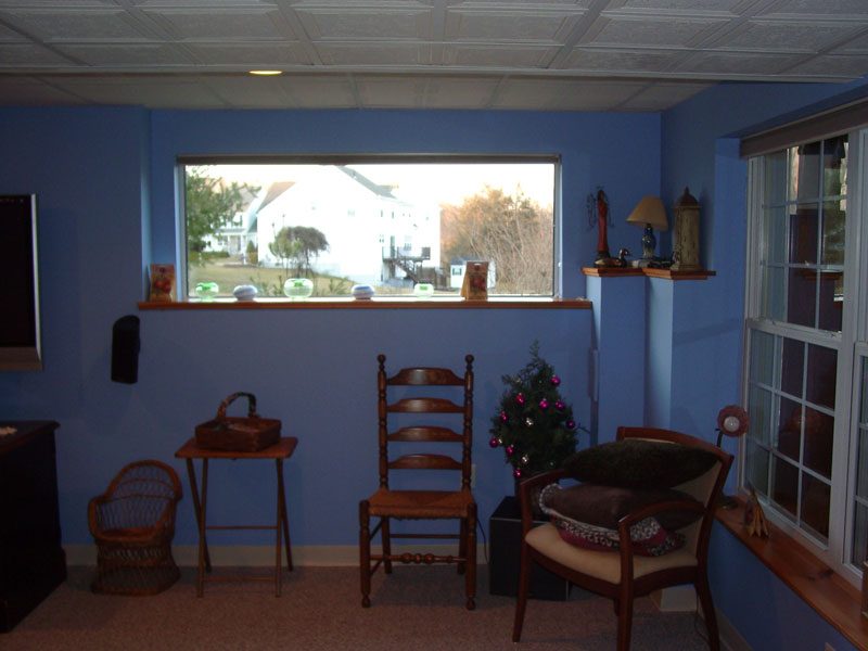 A finished basement with a garden view picture window