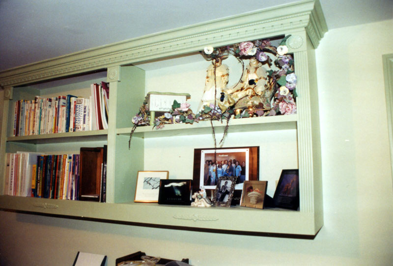 A built-in bookshelf with crown molding adds storage as well as interest to this room.